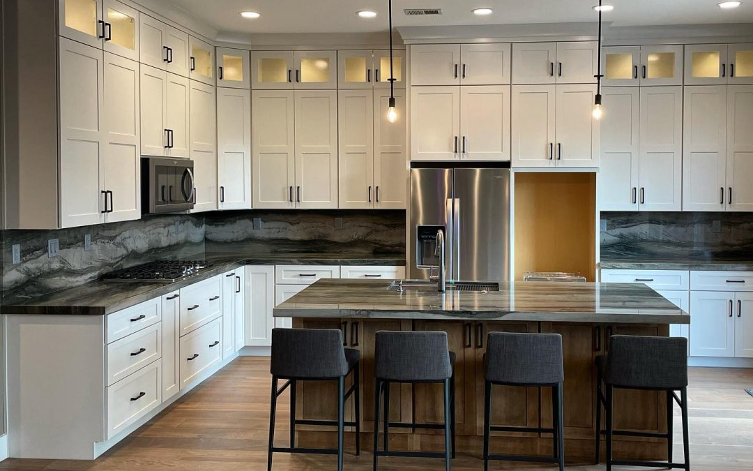 Modern kitchen with white cabinets, stainless appliances, island with sink, and four dark bar stools.
