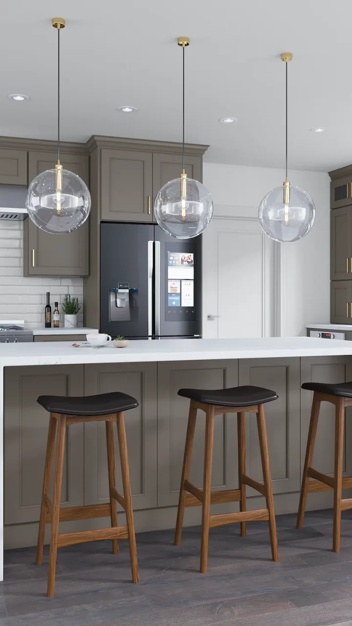 Modern kitchen with gray cabinets, a white island, three wooden stools, and globe pendant lights overhead.